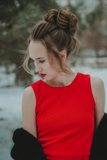 a woman in a red dress standing in the snow, hair styled in a bun, portrait featured on unsplash, teenage girl, gif