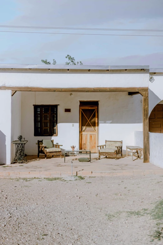 a white house sitting on top of a dirt field, courtyard walkway, rustic setting, serene desert setting, classic vibes