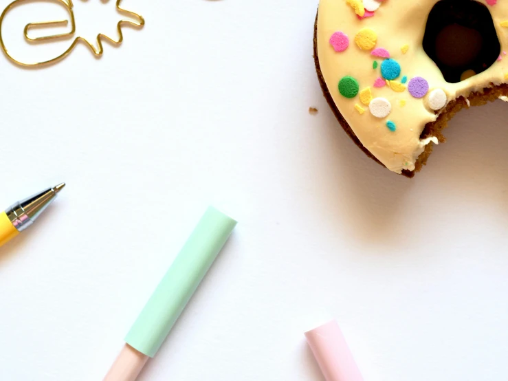 a white table topped with a donut covered in sprinkles, a child's drawing, trending on pexels, minimalism, background image, felt tip pen, gold and teal color scheme, pastel green