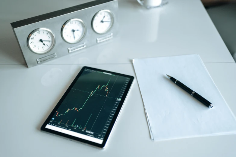 a tablet computer sitting on top of a white table, a picture, trending on pexels, analytical art, cryptocurrency, tubes and gauges, 3 pm, traders