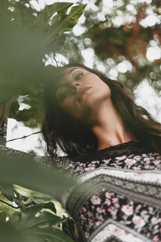 a woman standing in a tree looking up, inspired by Elsa Bleda, trending on pexels, renaissance, young woman with long dark hair, patterned clothing, zoomed in, woman made of plants