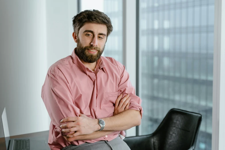 a man sitting at a desk with his arms crossed, inspired by Nelson Alexander Ross, pexels contest winner, hurufiyya, with a small beard, alex kanevsky, mit technology review, asmongold