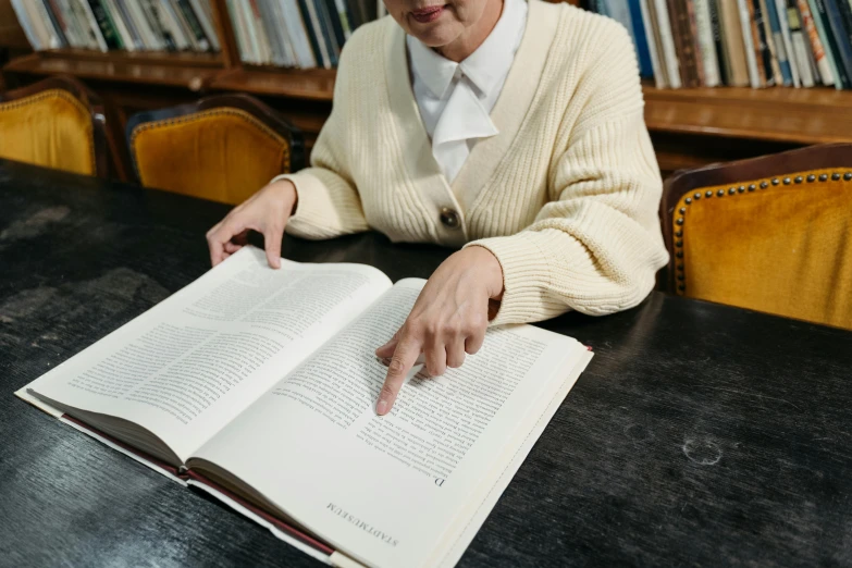 a woman sitting at a table reading a book, unsplash, hyperrealism, government archive photograph, background image, digital image, oyama kojima