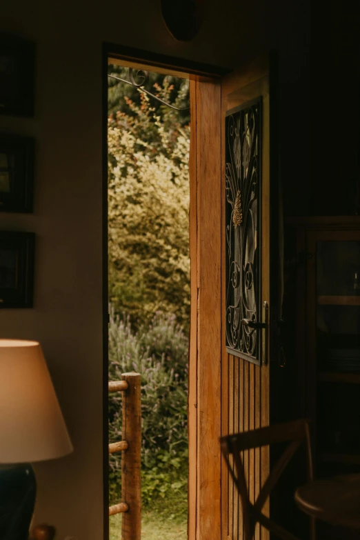 a living room filled with furniture and a lamp, a picture, by Peter Churcher, unsplash, arts and crafts movement, balcony door, cottage close up, backlighted, lush surroundings