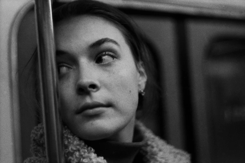 a black and white photo of a woman on a train, inspired by Louis Stettner, pexels, portrait of florence pugh, color 3 5 mm, andrey tarkovsky, portrait cute-fine-face