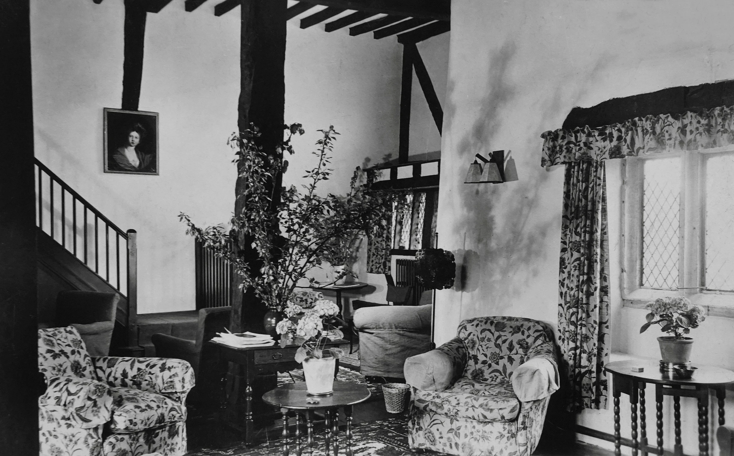 a black and white photo of a living room, by Vanessa Bell, flowers and foliage, inside a medieval hobbit home, marie - gabrielle capet style, listing image