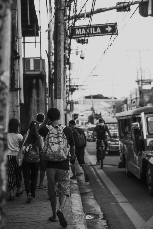 a black and white photo of people walking down a street, by Robbie Trevino, pexels contest winner, philippines, with a backpack, ( ( ( buses, japanese neighborhood