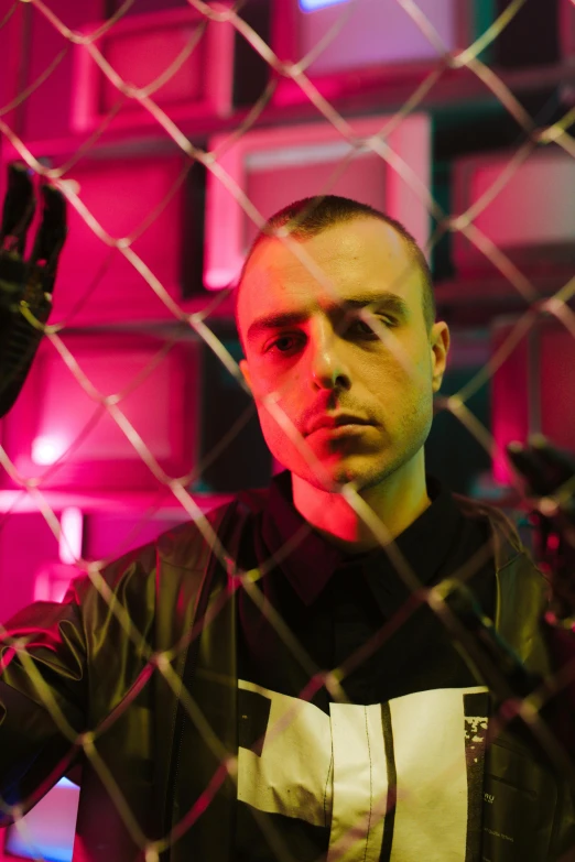 a man standing in front of a chain link fence, an album cover, inspired by Alexander Fedosav, unsplash, graffiti, buzz cut hair, charli xcx, intense expression, wearing japanese techwear