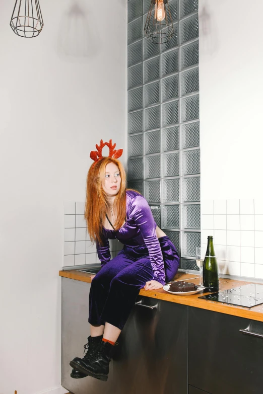 a woman sitting on a counter in a kitchen, an album cover, inspired by Sarah Lucas, pexels contest winner, renaissance, hr ginger, purple outfit, antlers, christmas night