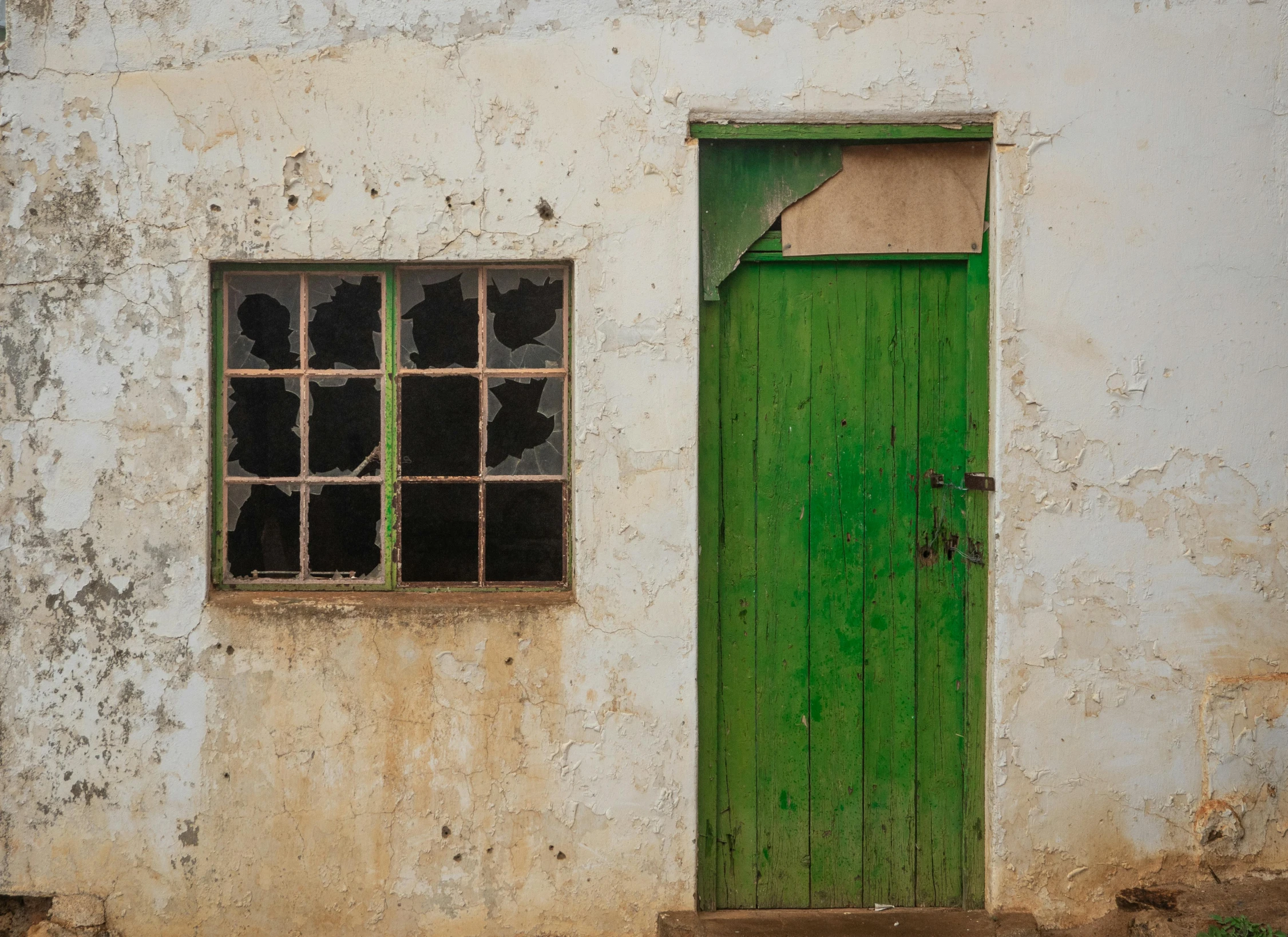 an old building with a green door and window, an album cover, by Peter Churcher, pexels contest winner, unmistakably kenyan, broken glass, minimalist photorealist, rural