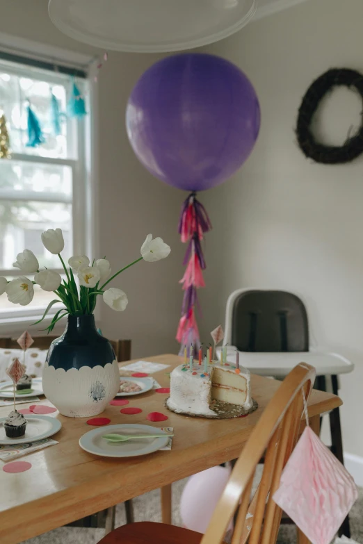 a table that has a bunch of plates on it, holding a balloon, profile image, party hats, lilac