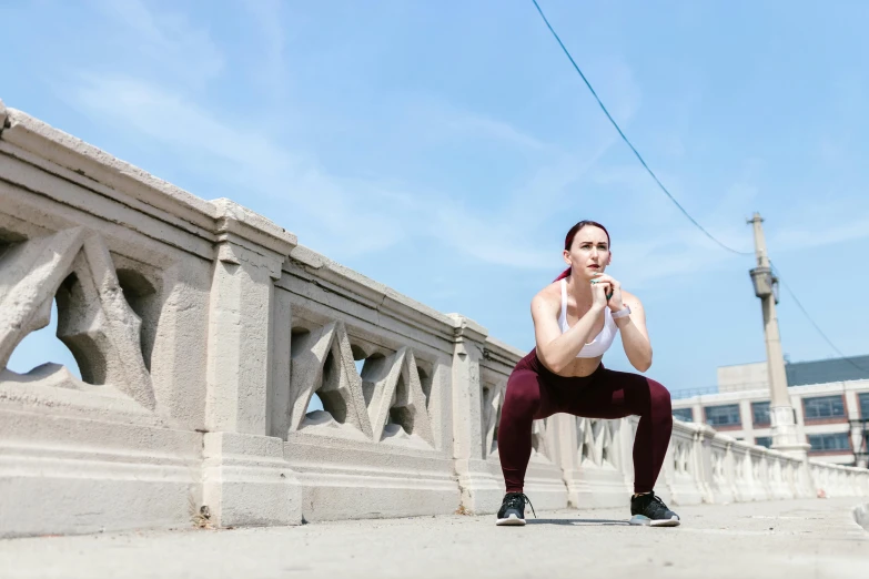 a woman sitting on a bridge talking on a cell phone, by Julia Pishtar, pexels contest winner, curvy crossfit build, they are crouching, on the concrete ground, avatar image