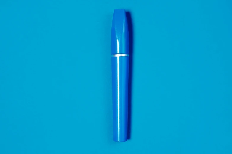 a blue pen sitting on top of a blue surface, mascara, product design shot, josh black, bright colour