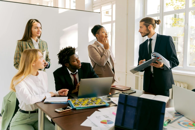 a group of people sitting around a table with laptops, a cartoon, trending on pexels, renaissance, wearing causal black suits, whiteboards, standing sideways, photo pinterest