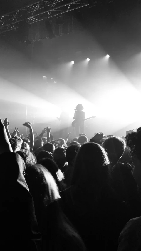 a black and white photo of a crowd at a concert, a black and white photo, by Matt Cavotta, pexels, stoner rock, phosphorescent, ::