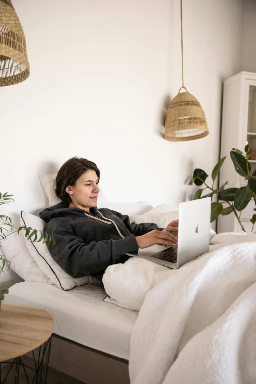 a woman laying on a bed with a laptop, by Maud Naftel, happening, cozy room, profile image