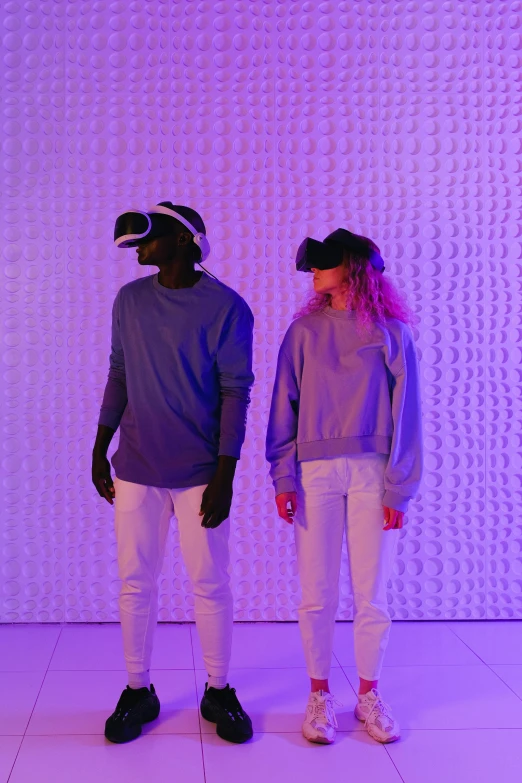 two people standing in front of a purple wall, pexels, interactive art, vr iridium visor, smart textiles, head down, visor covering eyes