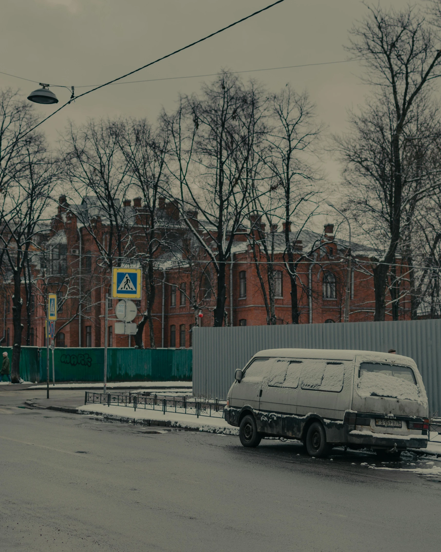 a car is parked on the side of the road, inspired by Vasily Surikov, pexels contest winner, socialist realism, brick building, winter photograph, low quality photo, complex and desaturated