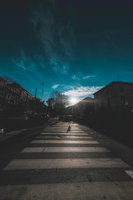 a street with a crosswalk in the middle of it, an album cover, by Niko Henrichon, unsplash contest winner, sunlit sky, today\'s featured photograph 4k, sun and shadow, cold light