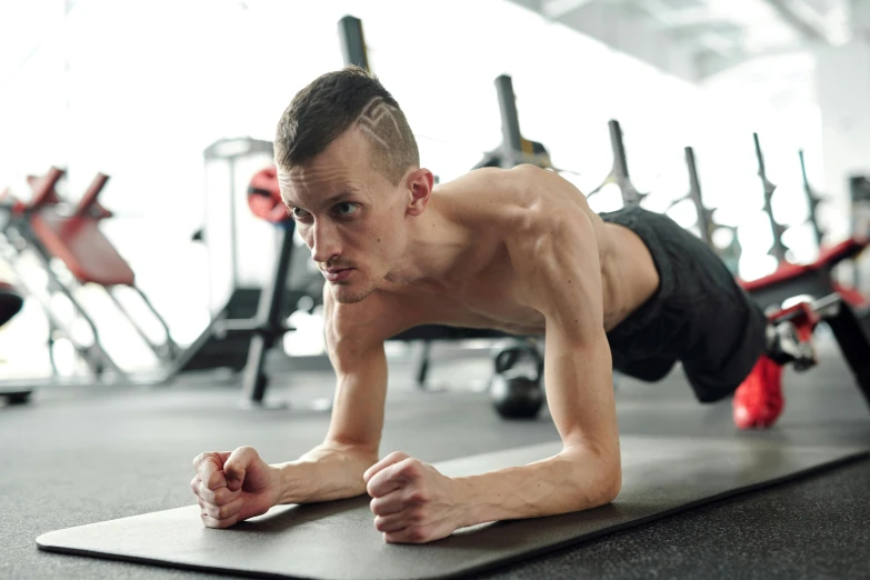 a man doing push ups on a mat in a gym, by Adam Marczyński, pexels contest winner, hyperrealism, skinny face, australian, thumbnail, 6 pack