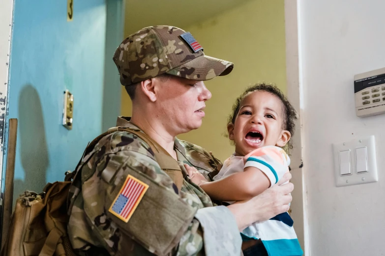 a woman in a military uniform holding a baby, ptsd, puerto rico, avatar image, getty images