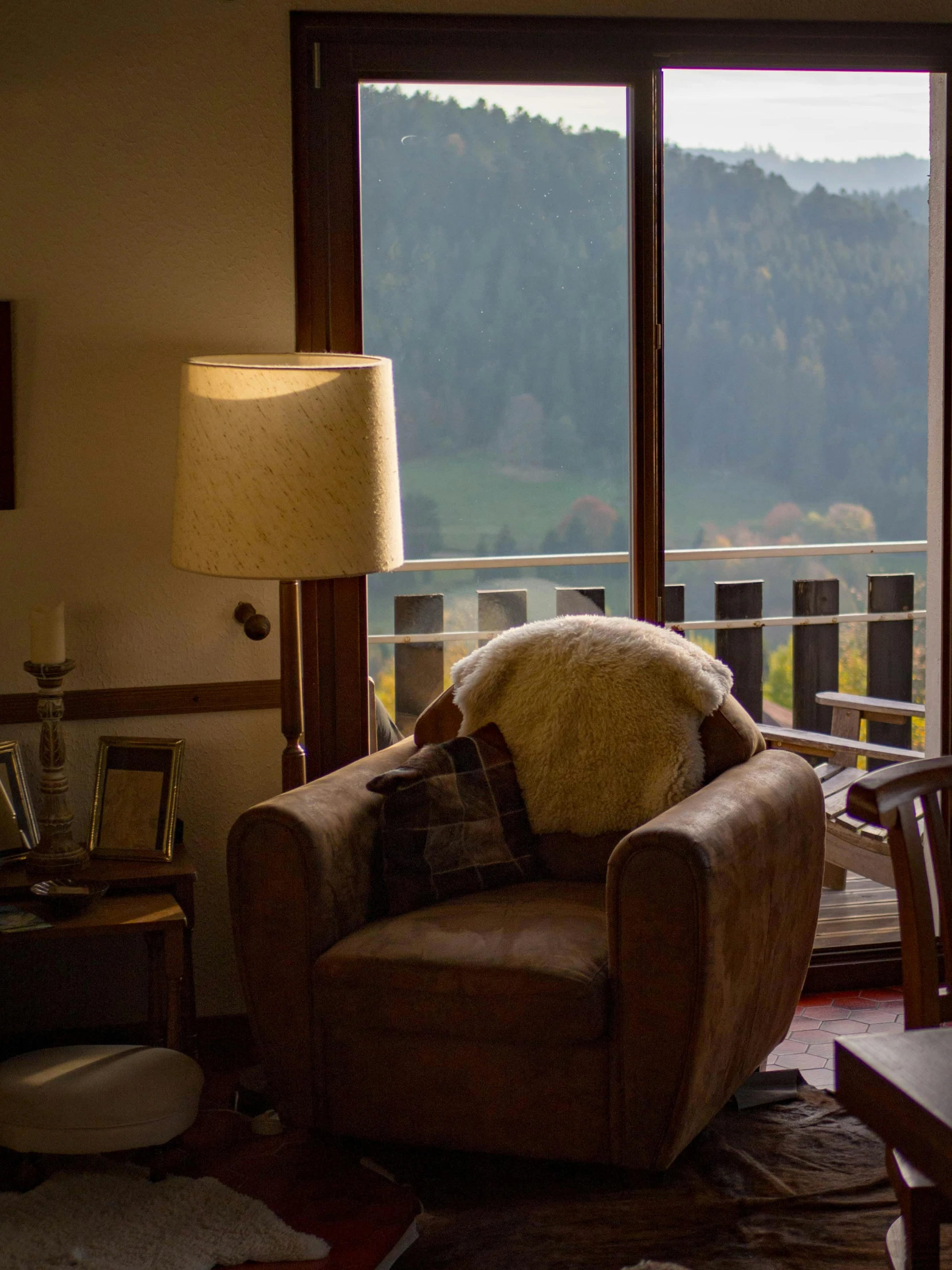 a living room filled with furniture and a large window, by Sebastian Spreng, pexels contest winner, overlooking a valley, cozy arm chairs, warm living room, in the swiss alps