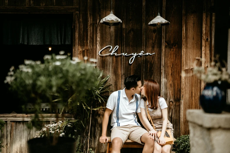 a man and woman sitting on a bench in front of a building, a picture, by Cherryl Fountain, pexels contest winner, stood outside a wooden cabin, heonhwa choe, profile image, background image