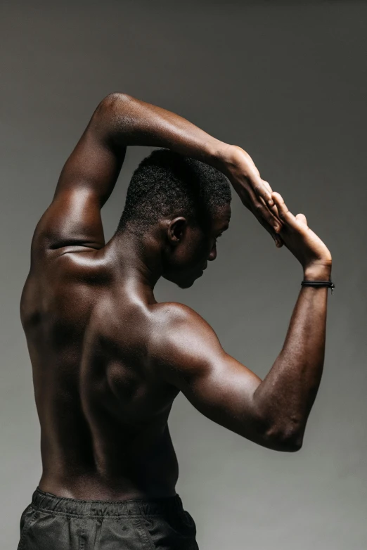 a man that is standing up with his hands on his head, pexels contest winner, black arts movement, bare bodybuilder shoulders. kohl, adut akech, in profile, lois greenfield
