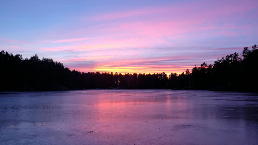 a sunset over a frozen lake with trees in the background, inspired by Jaakko Mattila, pexels contest winner, hurufiyya, pink, lake blue, body of water, white