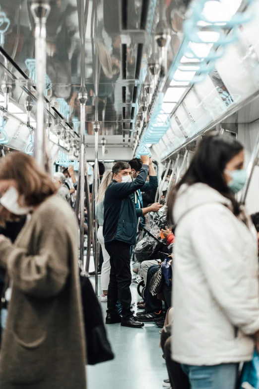 a group of people standing next to each other on a train, trending on pexels, happening, coronavirus, busy streets filled with people, surgery, underground