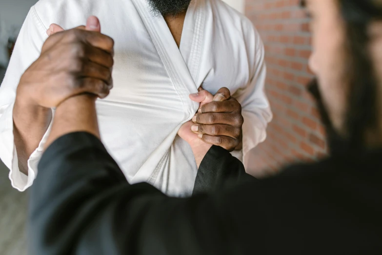 a man putting a tie on another man's shirt, by Carey Morris, pexels contest winner, happening, karate outfit, white bandages on fists, wearing robes, thumbnail