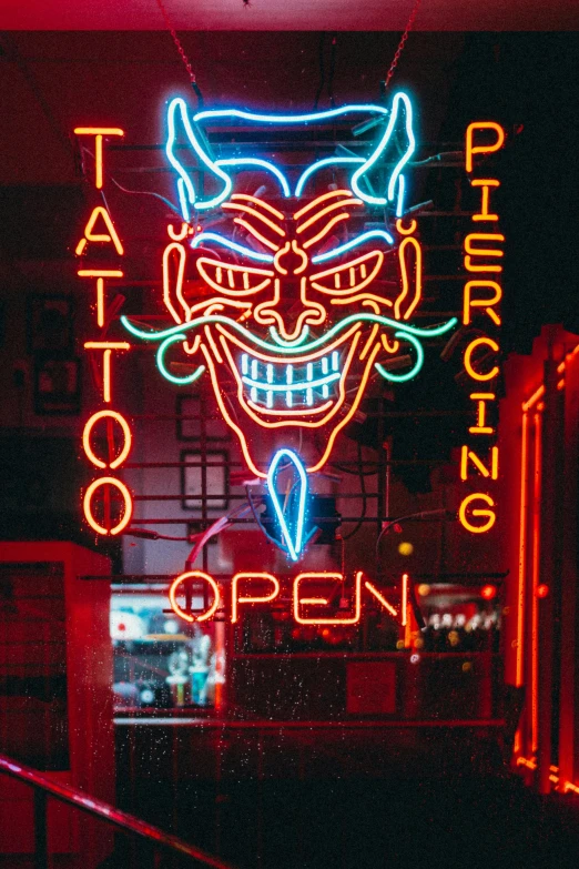 a neon sign hanging from the side of a building, a tattoo, facial piercings, devil's horns, 2019 trending photo, oriental tattoos