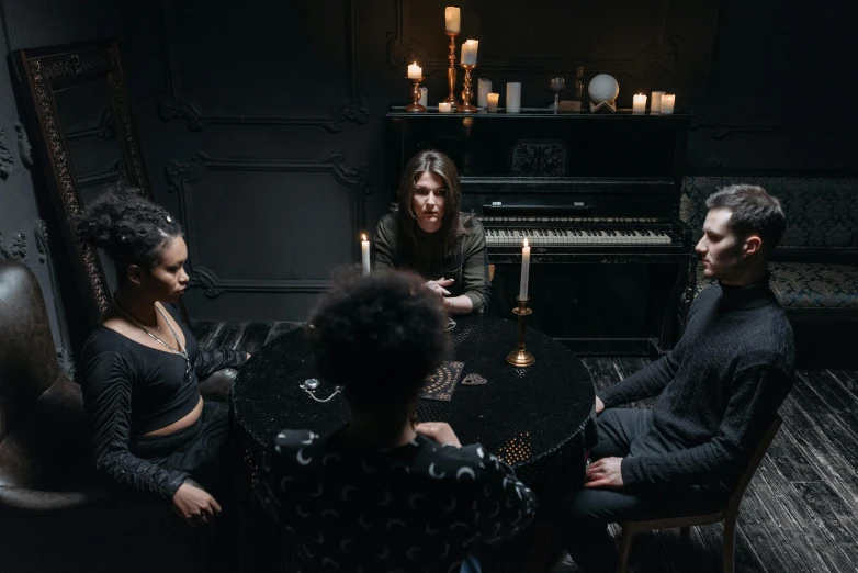 a group of people sitting around a table, an album cover, pexels contest winner, gothic mansion room, ( ( theatrical ) ), black magic spells, epk