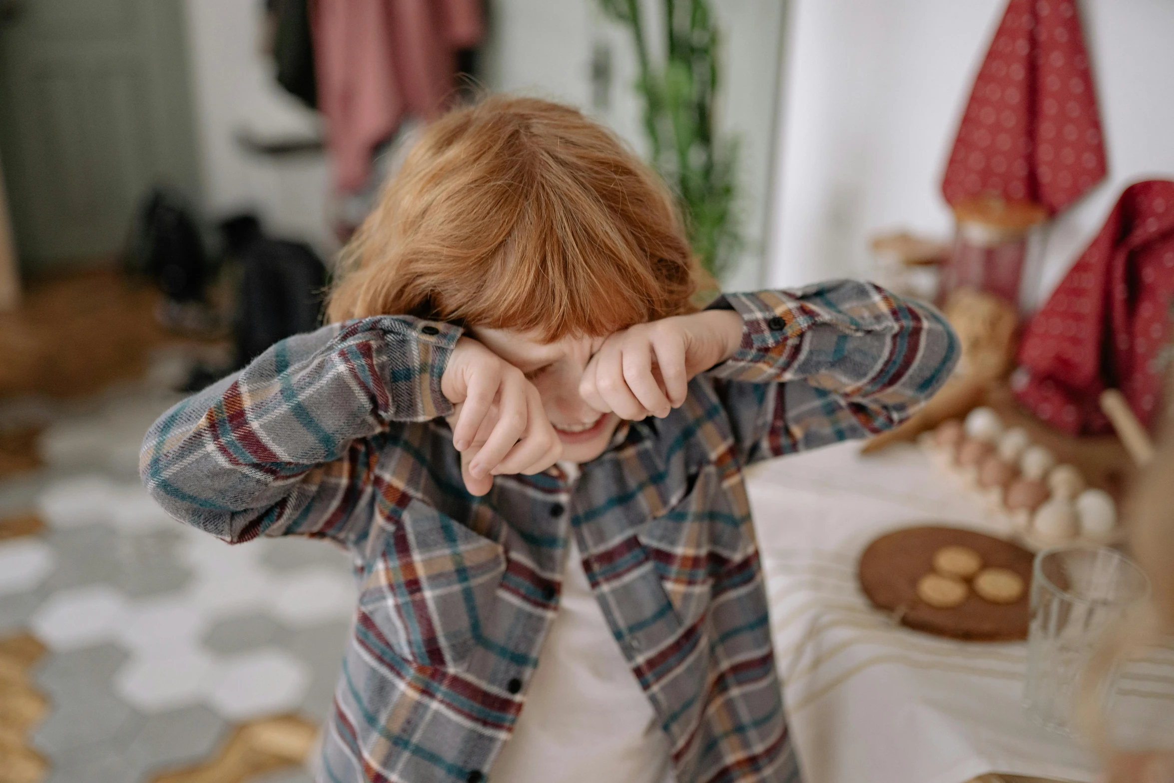 a woman holding her hands in front of her face, trending on pexels, red haired teen boy, waking up, flannel, little kid