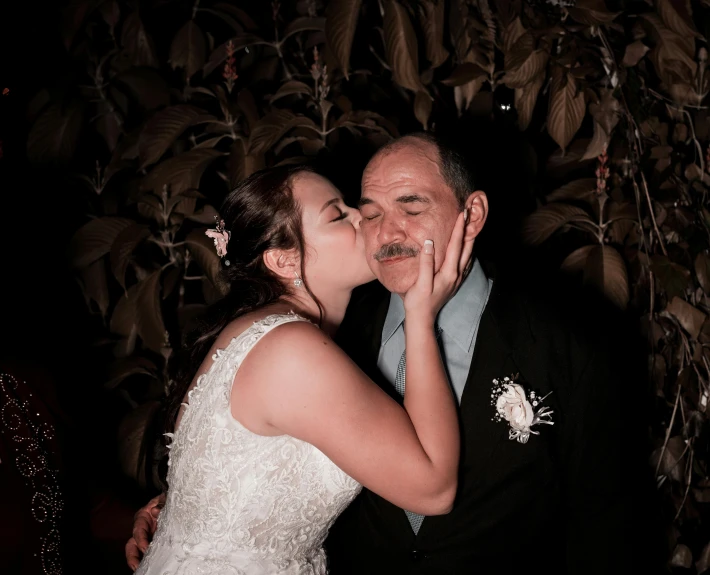 a bride and groom kissing in front of a tree, by Lucia Peka, pexels contest winner, happening, bushy moustache, momma and papa, taken in night club, te pae