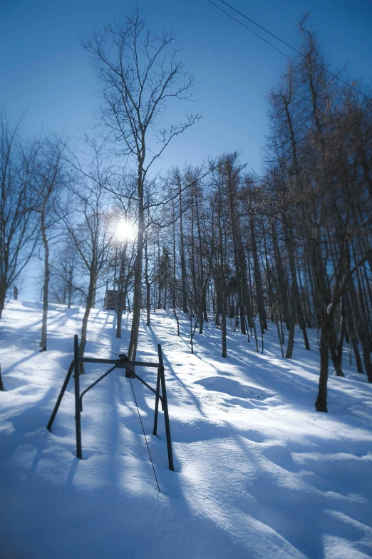 a bench sitting in the middle of a snow covered forest, an album cover, mingei, research station, the sun is shining wide shot, chairlifts, distant photo