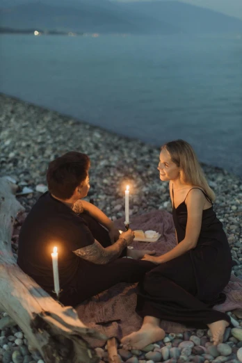 a man and woman sitting on a beach holding candles, intense flirting, unsplash photo contest winner, picnic, anna nikonova