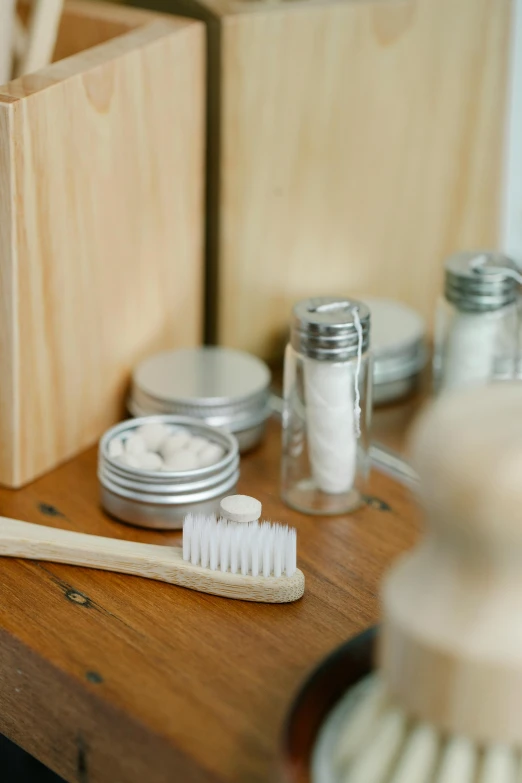 a toothbrush sitting on top of a wooden table, jars, detailed product image, wooden cabinet, detail shot