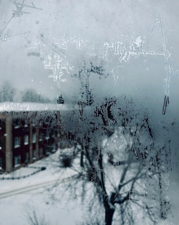 a view of a building through a frosty window, inspired by Elsa Bleda, pexels contest winner, graffiti, winter storm, low quality photo, ((oversaturated))