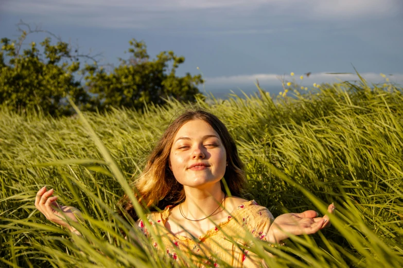 a young girl sitting in a field of tall grass, unsplash, happening, avatar image, sunbathed skin, a woman floats in midair, sydney sweeney