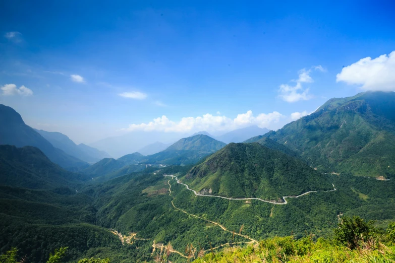 a view of a winding road in the mountains, an album cover, pexels contest winner, vietnam, clear blue skies, thumbnail, landslides