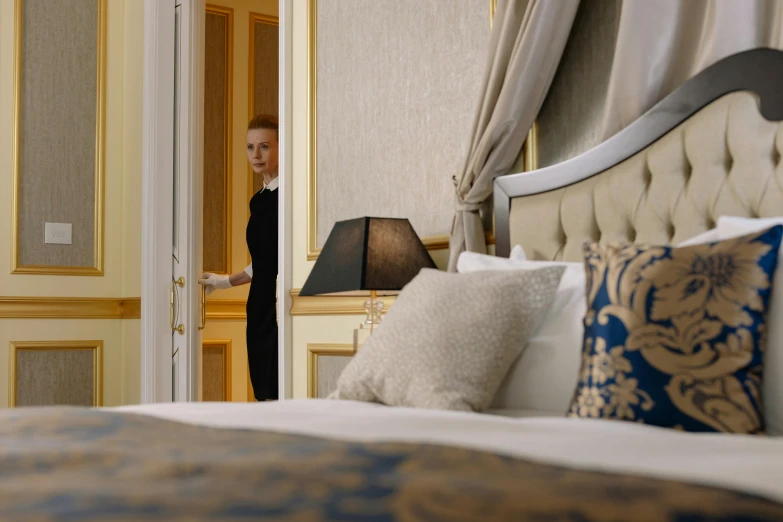 a woman standing in a bedroom next to a bed, paris hotel style, still from a live action movie, profile image, detail shot