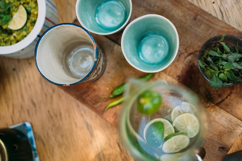 a wooden cutting board topped with bowls of food, unsplash, iced tea glass, blue and green colours, assam tea garden setting, raku