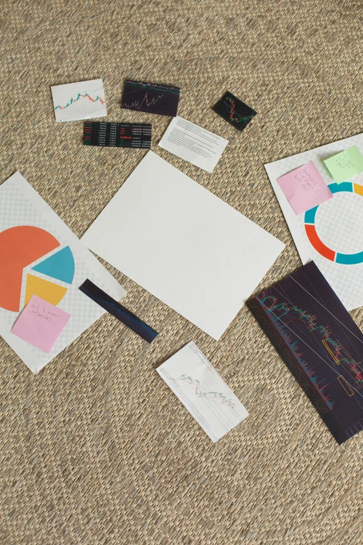 a pile of papers sitting on top of a carpet, a picture, analytical art, informative graphs and diagrams, cardstock, whiteboards, seen from straight above