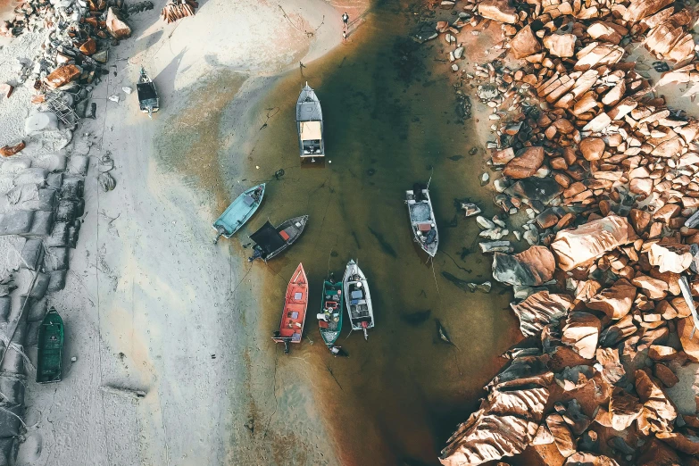 a group of boats sitting on top of a river, pexels contest winner, photorealism, top - down photograph, south african coast, rusty colors, beach aesthetic