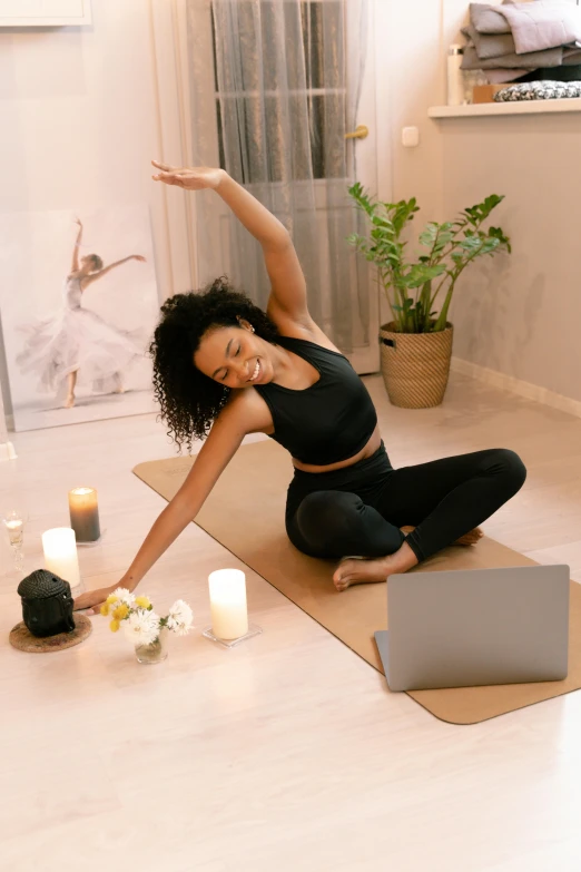 a woman sitting on a yoga mat in front of a laptop, renaissance, arms out, curated collections, candlelit, dynamic stretching