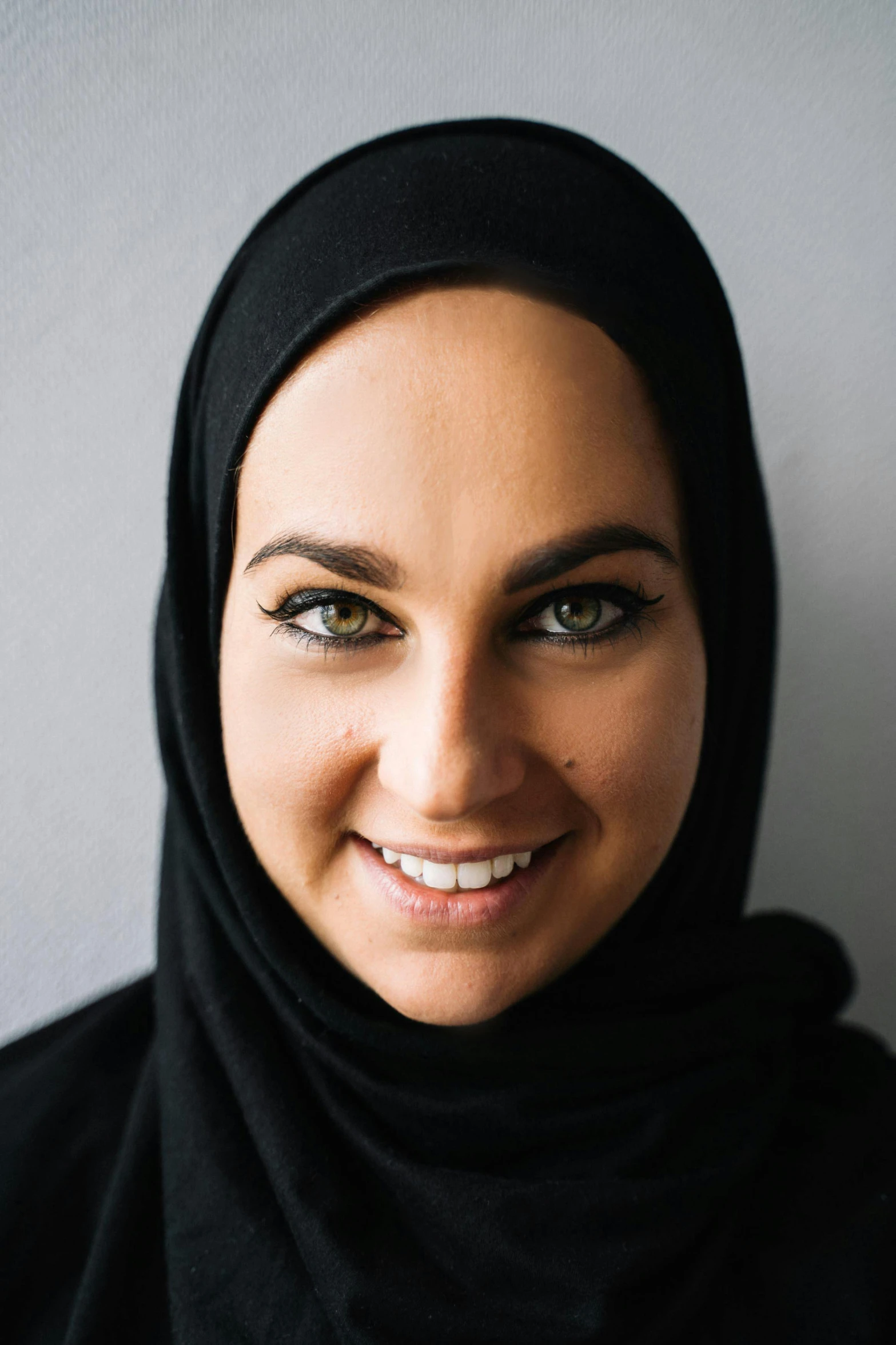 a close up of a person wearing a headscarf, vp of marketing, rectangle, arabian, dark