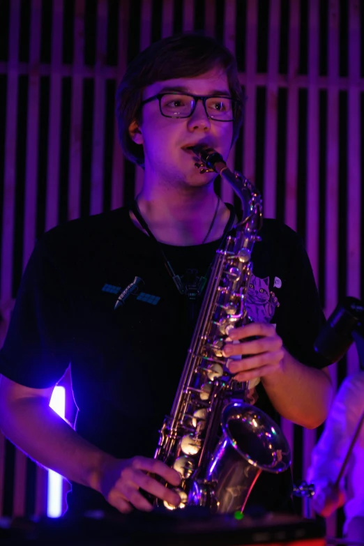 a man that is standing up with a saxophone, lachlan bailey, bisexual lighting, neck zoomed in, 1 6 years old