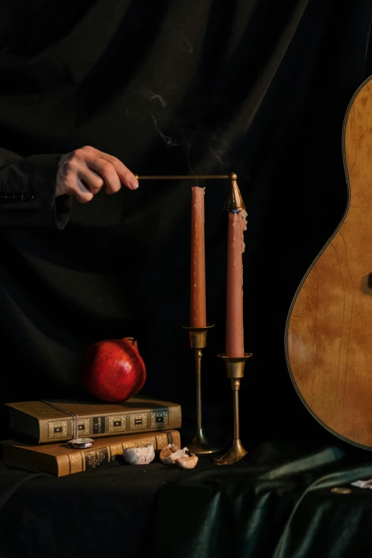 a guitar sitting on top of a table next to a candle, an album cover, inspired by William Michael Harnett, vanitas, holding a wooden staff, hans bellmer and nadav kander, middle close up composition, promotional image