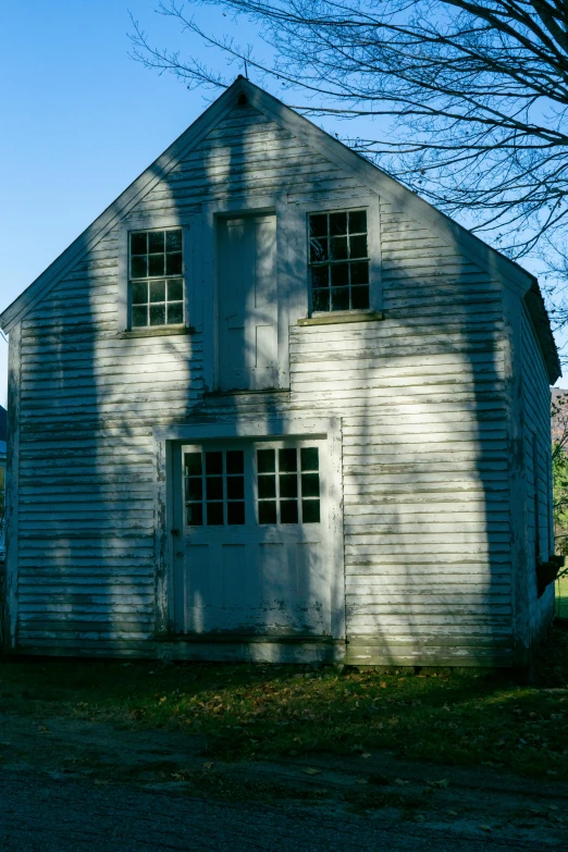 a white house sitting on the side of a road, a portrait, inspired by Andrew Wyeth, flickr, gambrel roof building, 1999 photograph, back rooms